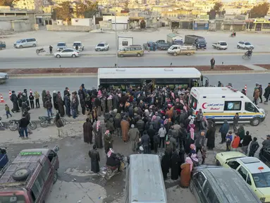 Foto udara menunjukkan pengungsi Suriah yang tinggal di Turki menunggu untuk naik bus melalui penyeberangan perbatasan Bab al-Hawa utara, pada 17 Februari 2023, saat mereka kembali ke Suriah setelah gempa bumi yang mematikan. Turki minggu ini mengizinkan warga Suriah di bawah perlindungannya yang memegang kartu identitas dari salah satu provinsi yang dilanda gempa untuk pergi antara tiga dan enam bulan. (AFP/Omar Haj Kadour)