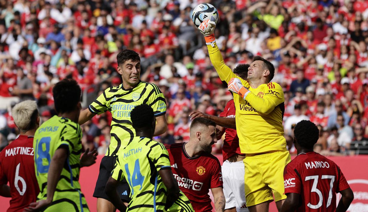 Kiper Manchester United, Tom Heaton berhasil meninju bola hasil sundulan gelandang Arsenal, Kai Havertz pada laga pramusim 2023/2024 di MetLife Stadium, New Jersey, USA, Minggu (23/7/2023) pagi WIB. (AFP/Getty Images/Rich Schultz)