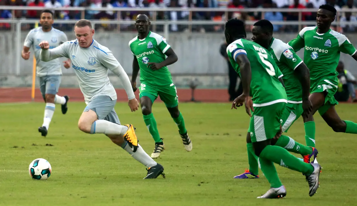 Striker Everton, Wayne Rooney (kanan) mencoba lolos dari kawalan pemain Gor Mahia pada pertandingan persahabatan di Tanzania, Kamis (13/7).  Rooney kembali tampil dalam seragam Everton setelah resmi meninggalkan Manchester United. (AP Photo/Khalfan Said)