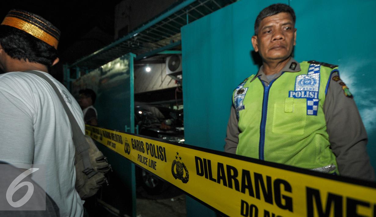 Petugas membentangkan garis polisi gudang yang diduga digunakan untuk membuat sabu, Jakarta (25/7). Kepolisian Polda Metro Jaya menggerebek sebuah gudang yang diduga pabrik narkoba jenis sabu di kawasan Penjaringan. (Liputan6.com/Yoppy Renato)