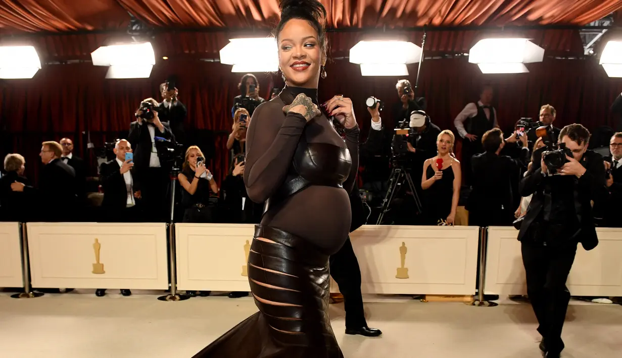 Rihanna tia untuk menghadiri Academy Awards ke-95 atau Oscar 2023 di Teater Dolby di Hollywood, California pada Minggu, 12 Maret 2023, waktu setempat. Rihanna yang tengah mengandung buah hati keduanya ini mengenakan gaun tersebut di atas bodysuit turtleneck tipis. (Photo by VALERIE MACON / AFP)