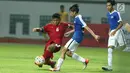 Kapten Timnas Indonesia U-16, Kartika Vedayanto Putra (kiri) mencoba melewati kawalan pemain Singapura U-16 saat laga persahabatan di Stadion Wibawa Mukti, Kab Bekasi, Kamis (8/6). Indonesia U-16 menang telak 4-0. (Liputan6.com/Helmi Fithriansyah)