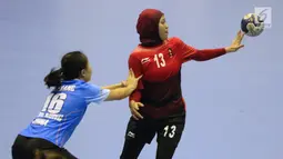 Pemain bola tangan putri Indonesia, Putri Dwi Merdekawati (kanan) berebut bola dengan Tsang Yuen Lam (Hong Kong) pada kualifikasi 7-8 Bola Tangan Putri Asian Games 2018 di Jakarta, Rabu (29/8). Indonesia menyerah 16-30. (Liputan6.com/Helmi Fithriansyah)