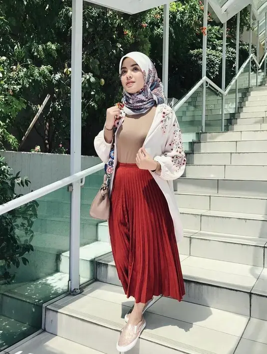 Ide outfit ke kampus yang stylish dan feminin, bisa sontek OOTD berikut ini. Padukan outerwear dengan rok plisket warna merah maroon. (Instagram/vebbypalwinta).