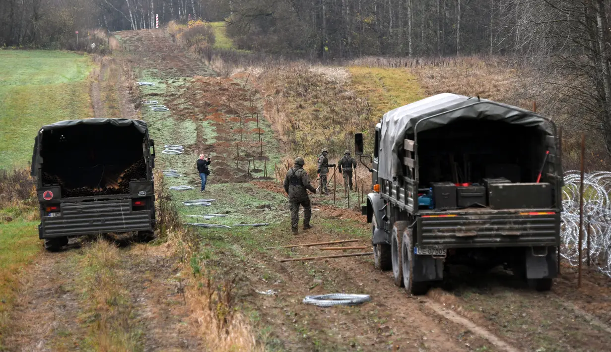 Tentara Polandia mulai memasang penghalang kawat berduri di sepanjang perbatasan Polandia dengan eksklave Rusia, Kaliningrad di Wisztyniec, Polandia, Rabu (2/11/2022). Pemerintah Polandia mengatakan pihaknya bertindak untuk mencegah krisis migrasi di perbatasan itu. (AP Photo/Michal Kosc)