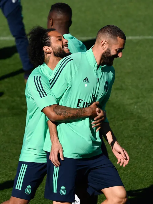 Bek Real Madrid Marcelo (kiri) bercanda dengan penyerang Karim Benzema saat sesi latihan di kompleks latihan Valdebebas, Madrid, Spanyol, Senin (30/9/2019). Real Madrid bersiap jelang menjamu Club Brugge dalam laga Liga Champions. (PIERRE-PHILIPPE MARCOU/AFP)