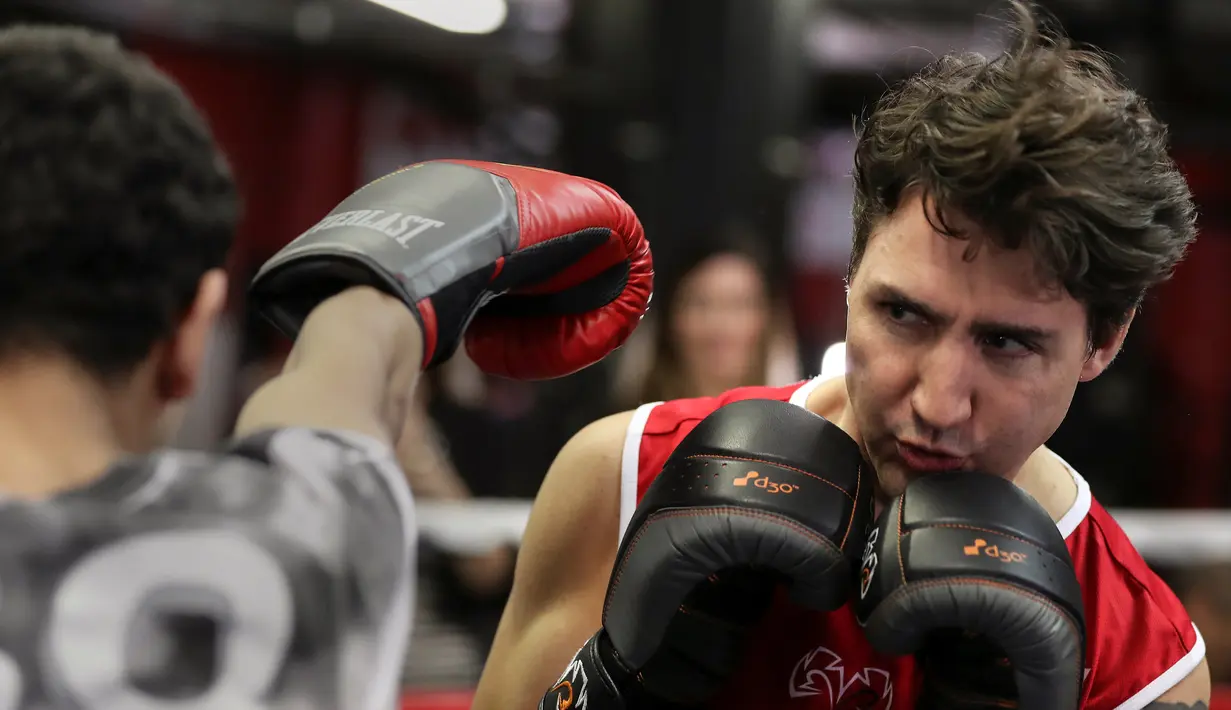 Perdana Menteri Kanada, Justin Trudeau menghindar dari pukulan petinju profesional Yuri Foreman di Gleason Boxing Gym di Brooklyn borough New York, AS (21/4). (REUTERS/Carlo Allegri)