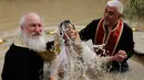 Seorang wanita Kristen Ortodoks Serbia dibaptis di perairan Sungai Yordan di dekat kota Jericho (4/3). Sungai ini diyakini menjadi tempat Yesus Kristus dibaptis oleh Yohanes Pembaptis. (AFP Photo/Gali Tibbon)