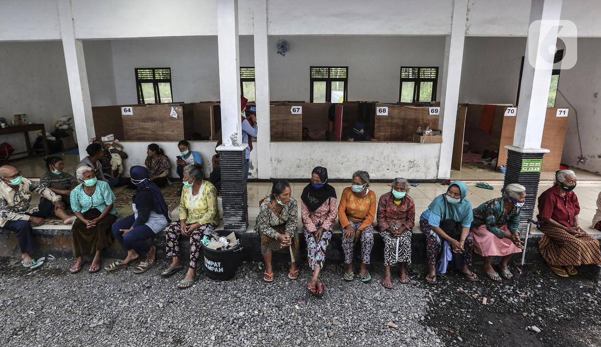 Pengungsi Gunung Merapi berkumpul di lokasi pengungsian di Desa Glagaharjo, Sleman, Jawa Tengah, Rabu (18/11/2020). Kondisi Gunung Merapi yang memasuki level siaga membuat beberapa desa dengan radius 5 Km dari puncak Gunung Merapi mengungsikan penduduknya. (Liputan6.com/Johan Tallo)