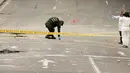 Polisi Kolombia dan ahli forensik memeriksa lokasi ledakan di dekat arena adu banteng Plaza Santamaria di pusat kota Bogota, Minggu (19/2). Hingga saat ini belum ada informasi yang detail terkait ledakan di arena adu banteng itu (AP Photo/Ricardo Mazalan)