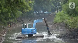 Pekerja mengoperasikan alat berat excavator untuk mengangkat material endapan lumpur di kanal sungai perkantoran Kuningan Jakarta, Rabu (17/2/2021). Pengerukan dilakukan untuk memperlancar aliran air agar tidak terjadi pendangkalan yang mengakibatkan genangan air. (merdeka.com/Imam Buhori)