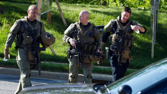 Aparat kepolisian mengamankan lokasi penembakan brutal di kantor surat kabar lokal Capital Gazette di Annapolis, Amerika Serikat (AS), Kamis (28/6). Akibat penembakan ini lima orang tewas dan tiga lainnya luka parah. (AP/Susan Walsh)