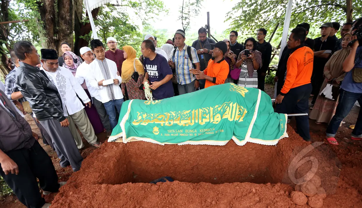 Jenazah enyanyi Yanni Rusiana Djunaedi (51) atau Yanni "Libels" saat akan dimasukkan ke liang lahat di TPU Tanah Kusir, Jakarta, Kamis (26/3/2015).  (Liputan6.com/Panji Diksana) 