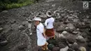 Dua anak melihat lahar dingin saat akan beribadah di sekitar Sungai Yeh Sah, Desa Batusesa, Kec Rendang, Karangasem, Bali, Jumat (1/12). Warga berharap diberi keselamatan dan berkah dari erupsi Gunung Agung yang terjadi. (Liputan6.com/Immanuel Antonius)