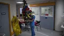 Pekerja rumah sakit Sonia Mokhtari menyiapkan pohon Natal untuk santap malam Natal di unit perawatan intensif COVID-19 di rumah sakit la Timone di Marseille, Prancis selatan, Jumat (24/12/2021). (AP Photo/Daniel Cole)