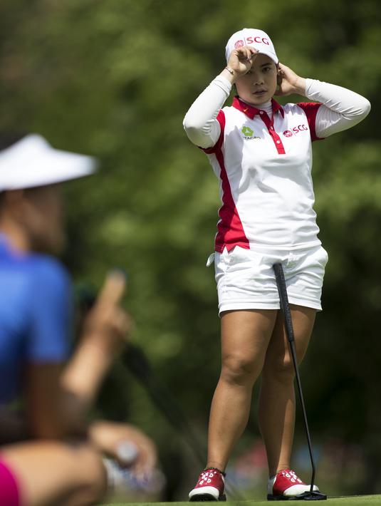 Moriya Jutanugarn, dari Thailand, menyaksikan Michelle Wie menempatkan puttnya di lubang ke-17 pada hari terakhir Meijer LPGA Classic di Blythefield Country Club di Grand Rapids, Mich, (18/6). (Mike Clark / Grand Rapids Press via AP)