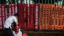 Pedagang merapikan syal Persija di kawasan Senayan, Jakarta, Minggu (9/12). Pedagang menjual aksesoris dan atribut Persija seperti baju, bendera, dan syal dengan kisaran harga Rp.50.000 - Rp. 100.000. (Liputan6.com/Faizal Fanani)