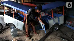 Asep menyelesaikan pembuatan odong-odong di Jakarta, Rabu (30/10/2019). Untuk pembuatan odong-odong jenis kereta mini, Asep mampu menyelesaikan dalam waktu 1 bulan yang dijual dengan harga kisaran Rp 25 juta (3 rangkaian) dan telah menembus pasar hingga luar Jawa. (merdeka.com/Iqbal S. Nugroho)