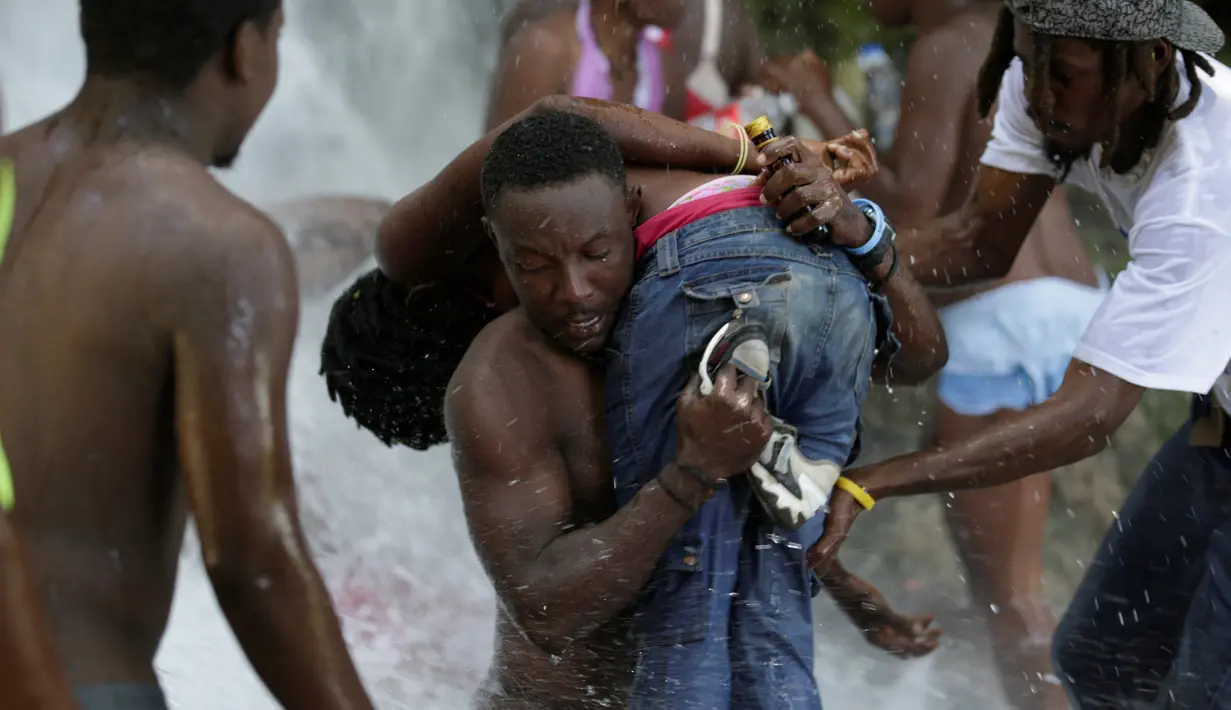 Sejumlah  peziarah mandi di bawah air terjun di Saut d' Eau, Haiti, (16/7). Ini merupakan ritual tahunan untuk menyembuhkan penyakit dan mensucikan diri. (REUTERS/Andres Martinez Casares)