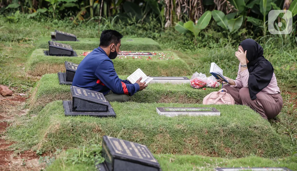 Umat Muslim berdoa di makam keluarga saat  melakukan ziarah di Tempat Pemakaman Umum (TPU) Pondok Ranggon, Jakarta, Minggu (04/04/21). Meskipun di tengah pandemi Covid-19 warga tetap melakukan tradisi ziarah kubur menjelang bulan Ramadan. (Liputan6.com/Faizal Fanani)