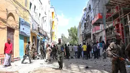 Petugas dan warga melihat lokasi serangan bom mobil di Distrik Hamarwayne, Mogadishu, Somalia (4/2). Menurut Polisi setempat, serangan bom mobil tersebut meledak di dekat sebuah mal di pasar. (AFP Photo/Abdirazak Hussein Farah)