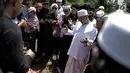 Penyanyi Opick berdoa di samping makam istri keduanya Wulan Mayasari di TPU Semper, Jakarta, Senin (19/3). Selama proses pemakaman ini, Opick didampingi oleh para santri dan kerabat dari perkumpulan komunitas bela diri. (Liputan6.com/Faizal Fanani)