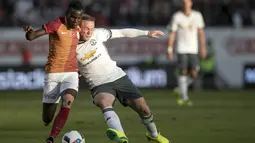 Kapten MU, Wayne Rooney, berusaha melewati pemain Galatasaray, Hakan Balta. Pada laga itu Rooney tampil baik dengan mencetak dua gol. (AFP/TT News Agency)