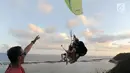 Dua wisatawan asal China melakukan tandem paralayang yang difasilitasi operator Riug Paragliding di Bukit Riug, Nusa Dua, Bali (30/6). Setiap wisatawan dikenai tarif 110 dollar/ orang untuk penerbangan selama 15 menit. (Merdeka.com/Arie Basuki)