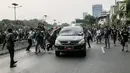 Massa aksi  melakukan penyerangan terhadap mobil pelat nomor merah yang melintasi jalan tol seberang Gedung DPR/ MPR RI, Jakarta, Selasa (24/9/2019). Selain menutup ruas tol, kendaraan dinas pemerintah dan milik polisi jadi korban pelemparan dan perusakan oleh mahasiswa. (Liputan6.com/Faizal Fanani)