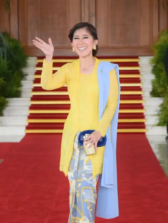 Kian anggun, penampilannya dipermanis dengan aksesori seperti anting berwarna kekuningan, kalung minimalis, dan handbag warna biru dongker.