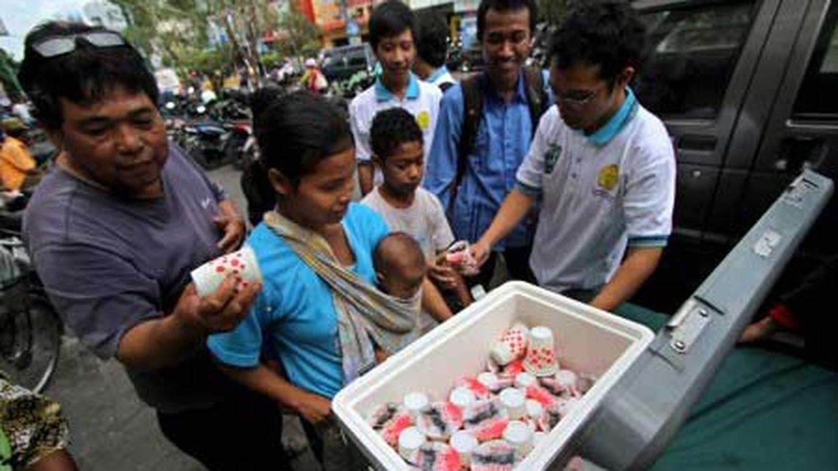 Sejumlah warga berebut mendapatkan susu gratis yang dibagikan di Jl