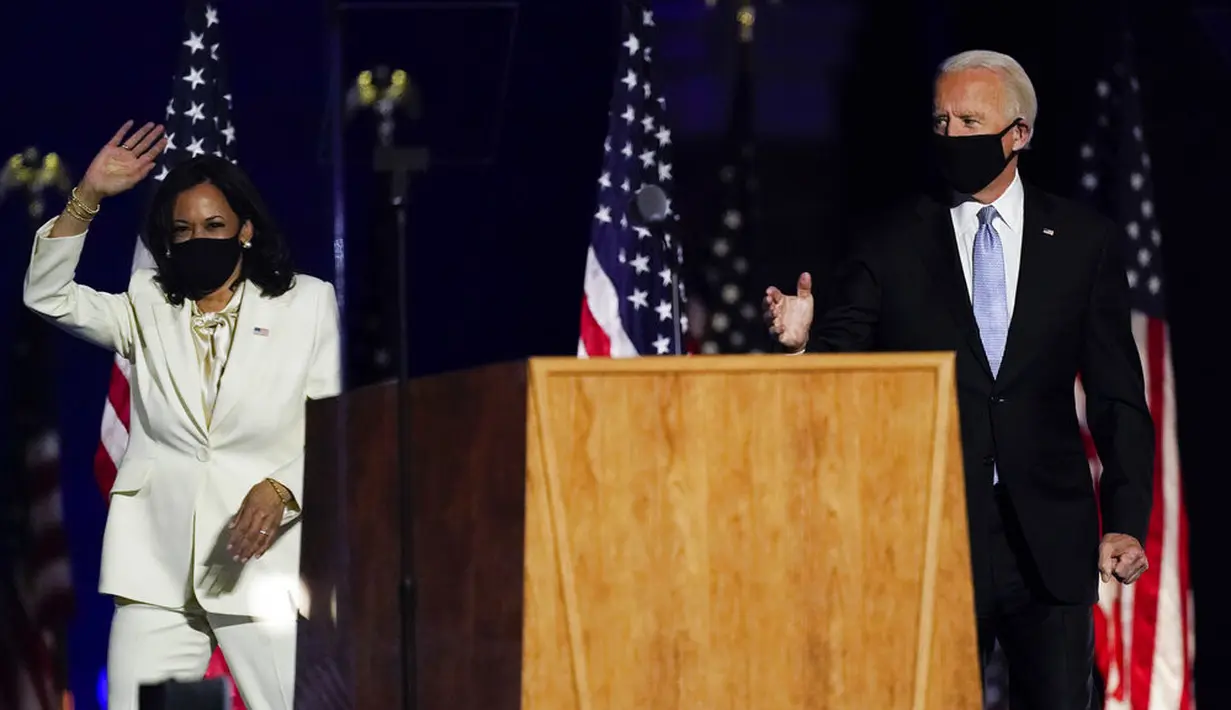 Presiden terpilih Joe Biden dan Wakil Presiden terpilih Kamala Harris melambaikan tangan ke kerumunan saat menyampaikan pidato kemenangan Pilpres AS 2020 di Wilmington, Delaware, Amerika Serikat, Sabtu (7/11/2020). Joe Biden dan Kamala Harris memenangkan Pilpres AS 2020. (AP Photo/Andrew Harnik)