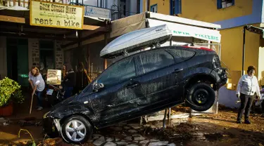 Sebuah mobil di depan toko rental kendaraan rusak akibat diterjang banjir bandang yang melanda pulau Symi di Yunani, Rabu (15/11). Banjir bandang itu melanda tiga kota terpisah di Negeri Dewa tersebut. (Argiris Madikos /Eurokinissi via AP)