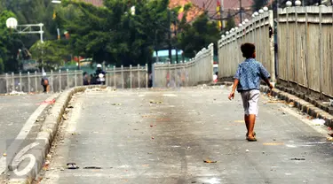 Seorang anak melintas di Jalan Jatinegara Barat Jakarta, Kamis (20/8/2015). Jalan Jatinegara Barat ditutup saat penggusuran warga yang tinggal di bantaran Kali Ciliwung di Kampung Pulo, Jakarta Timur. (Liputan6.com/HelmiFithriansyah)