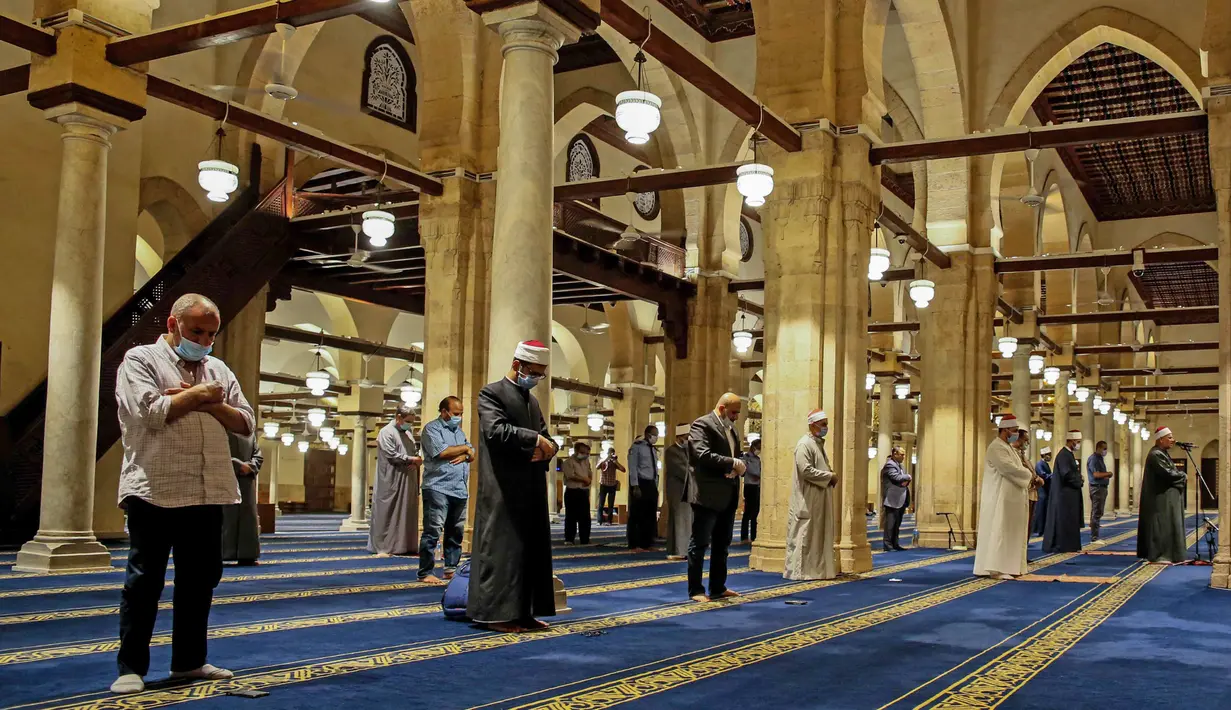 Umat Muslim melaksanakan salat tarawih dengan menerapkan jaga jarak selama bulan Ramadan di Masjid al-Azhar, Kairo, Minggu (17/5/2020). Bagi umat Islam di seluruh dunia menjalankan ibadah puasa tahun ini di tengah pembatasan akibat corona Covid-19 adalah yang pertama kalinya. (Samer ABDALLAH/AFP)