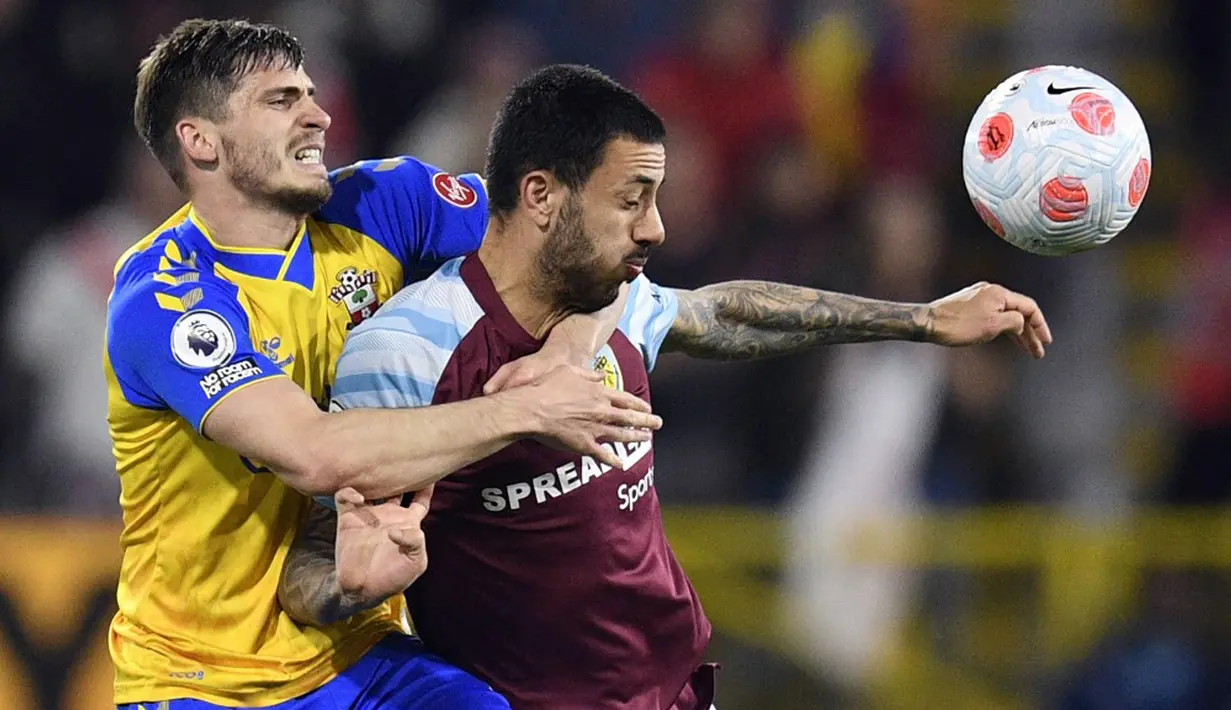 <p>Pemain Southampton Romain Perraud (kiri) berebut bola dengan pemain Burnley Dwight McNeil (kanan) pada pertandingan Liga Inggris di Turf Moor, Burnley, Inggris, 21 April 2022. Burnley menang 2-0. (Oli SCARFF/AFP)</p>