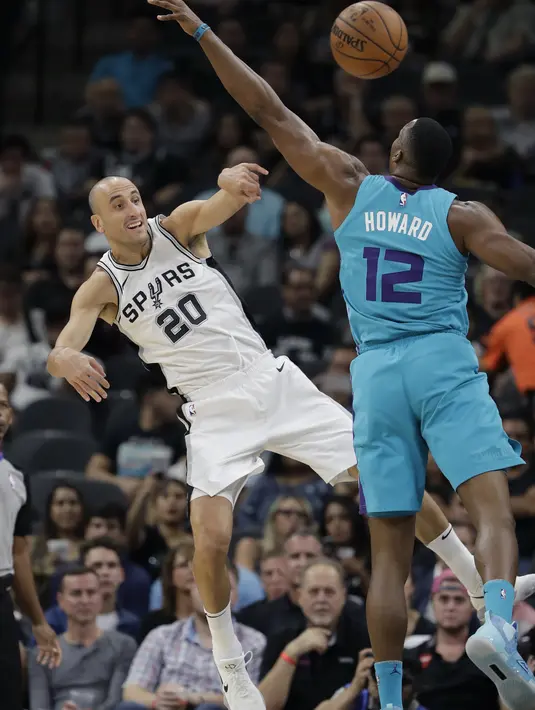 Aksi pemain Spurs, Manu Ginobili (20) melepaskan umpan saat diadang pemain Hornets, Dwight Howard (12) pada laga NBA basketball game di AT&T Center, San Antonio, (3/11/2017) waktu setempat. San Antonio menang 108-101. (AP/Eric Gay)