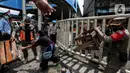 Aparat gabungan mengangkut dagangan pedagang yang berjualan di trotoar di kawasan Tanah Abang, Jakarta, Minggu (2/5/2021). Selain merazia barang dagangan pedagang, aparat gabungan juga menegur warga yang tidak menerapkan protokol kesehatan. (Liputan6.com/Johan Tallo)