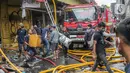 Pedagang menyelamatkan barang dagangan saat proses pendinginan oleh damkar dari kebakaran di Pasar Pagi Asemka, Jakarta, Jumat (18/11/2022). Dugaan penyebab sementara, berdasarkan informasi awal dari lokasi terjadi korsleting listrik," sebut Joko. (Liputan6.com/Faizal Fanani)
