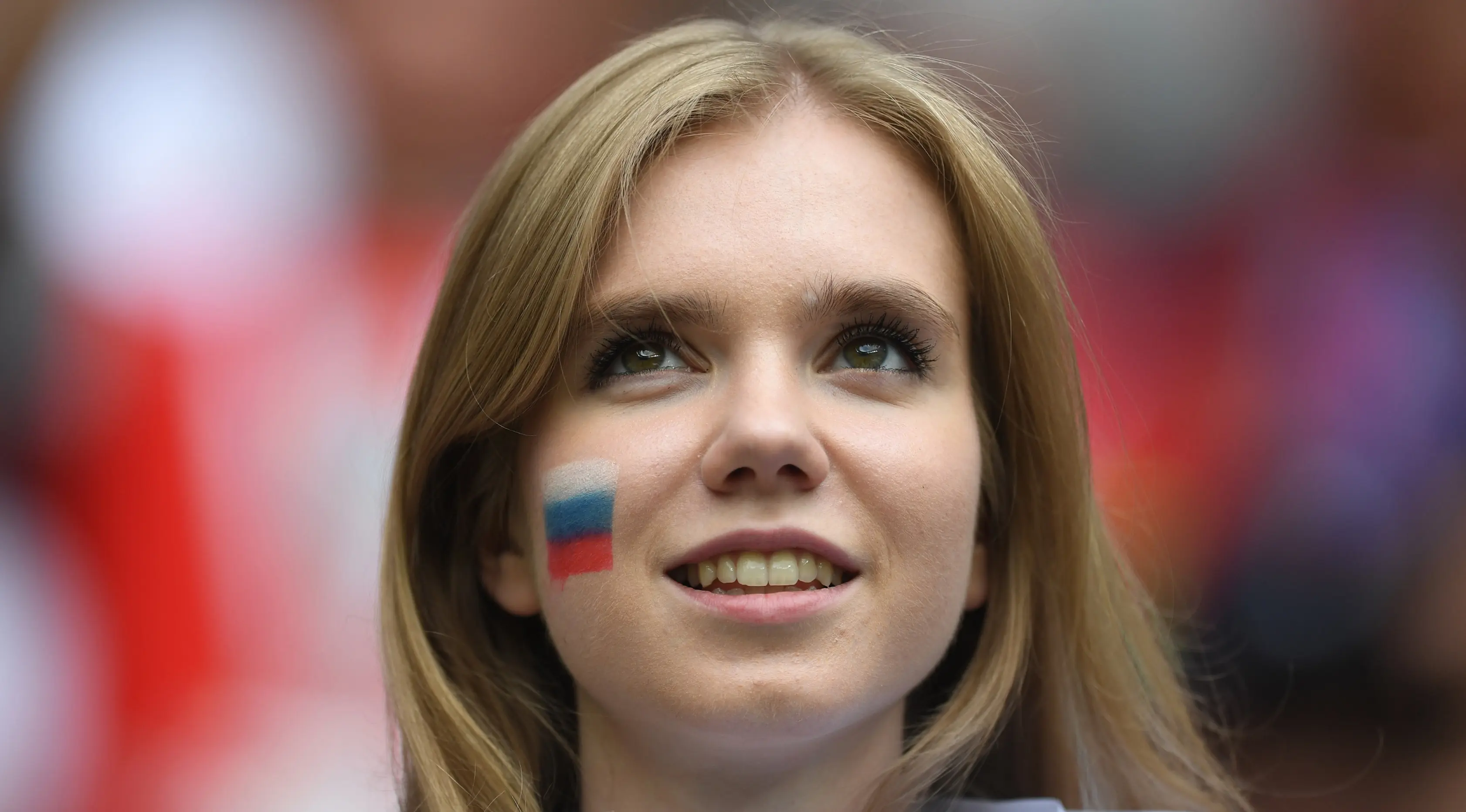 Suporter wanita tersenyum sebelum pertandingan grup A Piala Dunia 2018 antara Rusia dan Arab Saudi di stadion Luzhniki di Moskow, (14/6). Dalam pertandingan ini, Rusia menang 5-0 atas Arab Saudi. (AFP Photo / Francisco Leong)