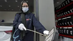 Seorang mekanik wanita Saudi membersihkan saringan udara bagian mobil di bengkel perbaikan dan servis di kota Jeddah, Arab Saudi (27/12/2021). Melalui program Vision 2030, kini semakin banyak wanita di Arab Saudi yang bekerja di bidang baru, seperti pramugari dan pengemudi taksi. (AFP/Amer Hilabi)