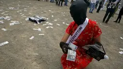 Wanita mengambil uang yang berjatuhan selama melakukan tetrikal dalam partisipasi mengungkap korupsi di Lima,Peru, (12/11/2015).  Mereka ingin menciptakan kepada masyarakat akan kesadaran tentang korupsi. (REUTERS/Mariana Bazo)