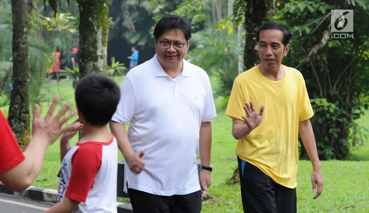 Presiden Joko Widodo atau Jokowi (kanan) dan Menteri Perindustrian Airlangga Hartarto menyapa warga saat olahraga bersama di sekitar Istana Bogor, Sabtu (24/3). Cuaca Bogor sedikit mendung saat keduanya berolahraga. (Liputan6.com/Pool/Biro Pers Setpres)