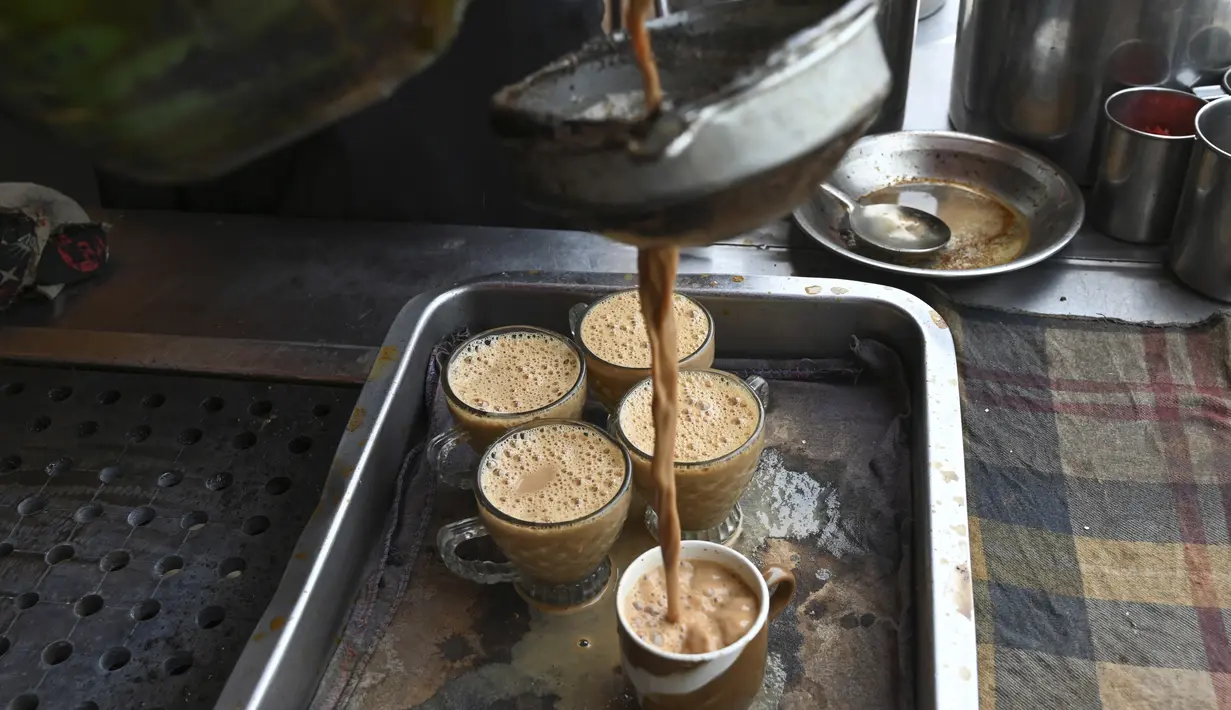 <p>Seorang pekerja menuangkan cangkir teh untuk pelanggan di sebuah restoran di Islamabad, Pakistan, Rabu (15/6/2022). Permintaan untuk mengurangi minum teh menjadi viral di media sosial. Banyak yang meragukan masalah keuangan negara yang serius dapat diatasi dengan menghentikan minuman berkafein tersebut. (Aamir QURESHI / AFP)</p>