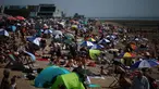 Orang-orang bersantai di kawasan Southend-on-Sea, bagian tenggara Inggris pada 12 Agustus 2024. (HENRY NICHOLLS/AFP)