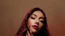 Wajahnya dipulas dengan makeup bold glam berlipstik merah gelap yang berani [@denadaindonesia]