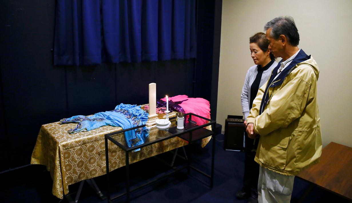 Hirokazu Hosaka (kanan) dan istrinya, Minako Hosaka mengamati peti mati ibunya di 'Corpse Hotel' di Kawasaki, Jepang, 20 April 2016. Tempat itu adalah kamar mayat yang didesain untuk menyimpan jenazah yang menunggu jadwal kremasi. (REUTERS/Thomas Peter)