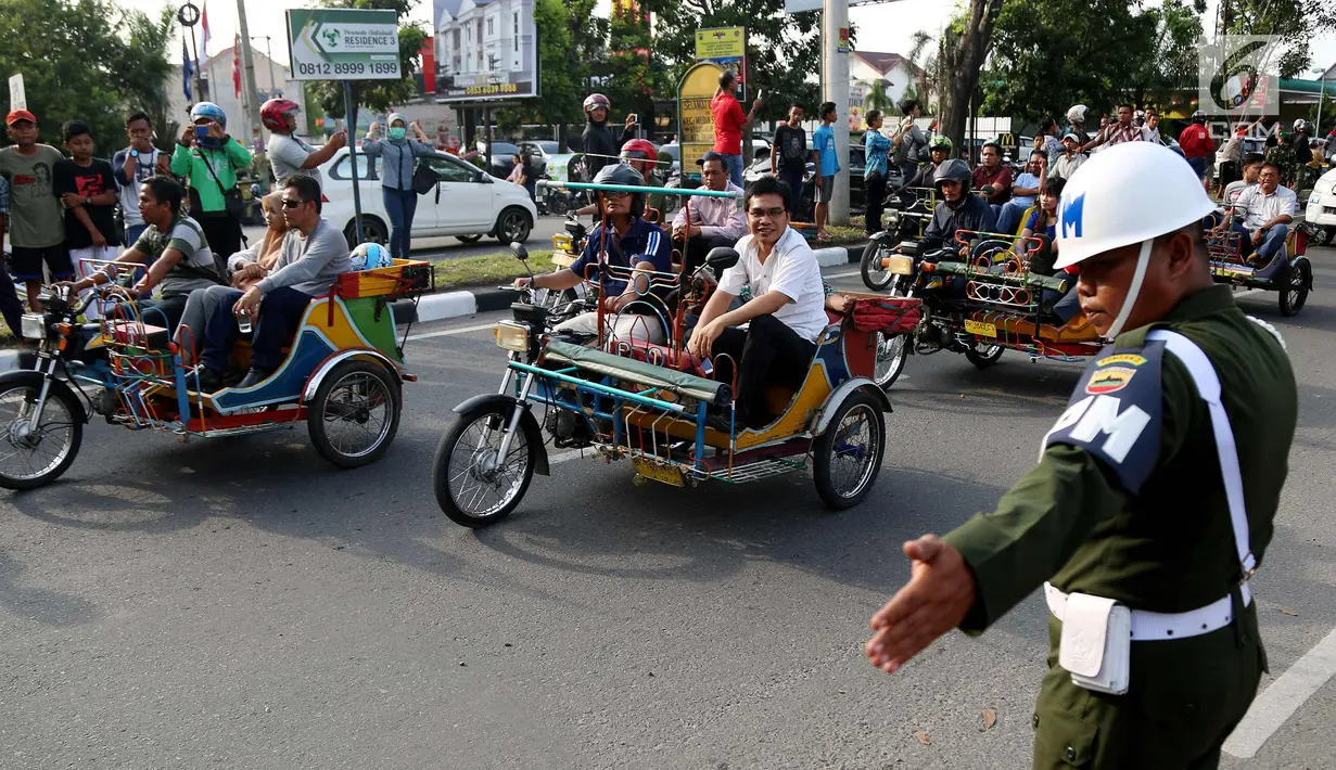 Petugas mengatur betor yang melintas saat gladi resik kirab Kahiyang Ayu dan Bobby Nasution di sepanjang jalan Gagak Hitam, Medan, Rabu (22/11). Sebanyak 37 betor akan mengiringi  arak-arakan ngunduh mantu Kahiyang-Bobby. (Liputan6.com/Johan Tallo)