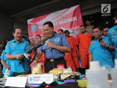 Kepala BNN Komjen Budi Waseso menunjukkan barang bukti beserta tersangka terkait kasus penyelundupan narkoba jaringan internasional di Kantor BNN, Jakarta, Selasa (10/10). BNN bongkar 4 sindikat narkoba jaringan internasional. (Liputan6.com/Faizal Fanani)