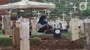 Warga melayat di area pemakaman jenazah COVID-19 di TPU Pondok Ranggon, Jakarta, Rabu (2/12/2020). TPU Pondok Ranggon  hanya melayani jenazah COVID-19 muslim dengan sistem tumpang. (Liputan6.com/Herman Zakharia)